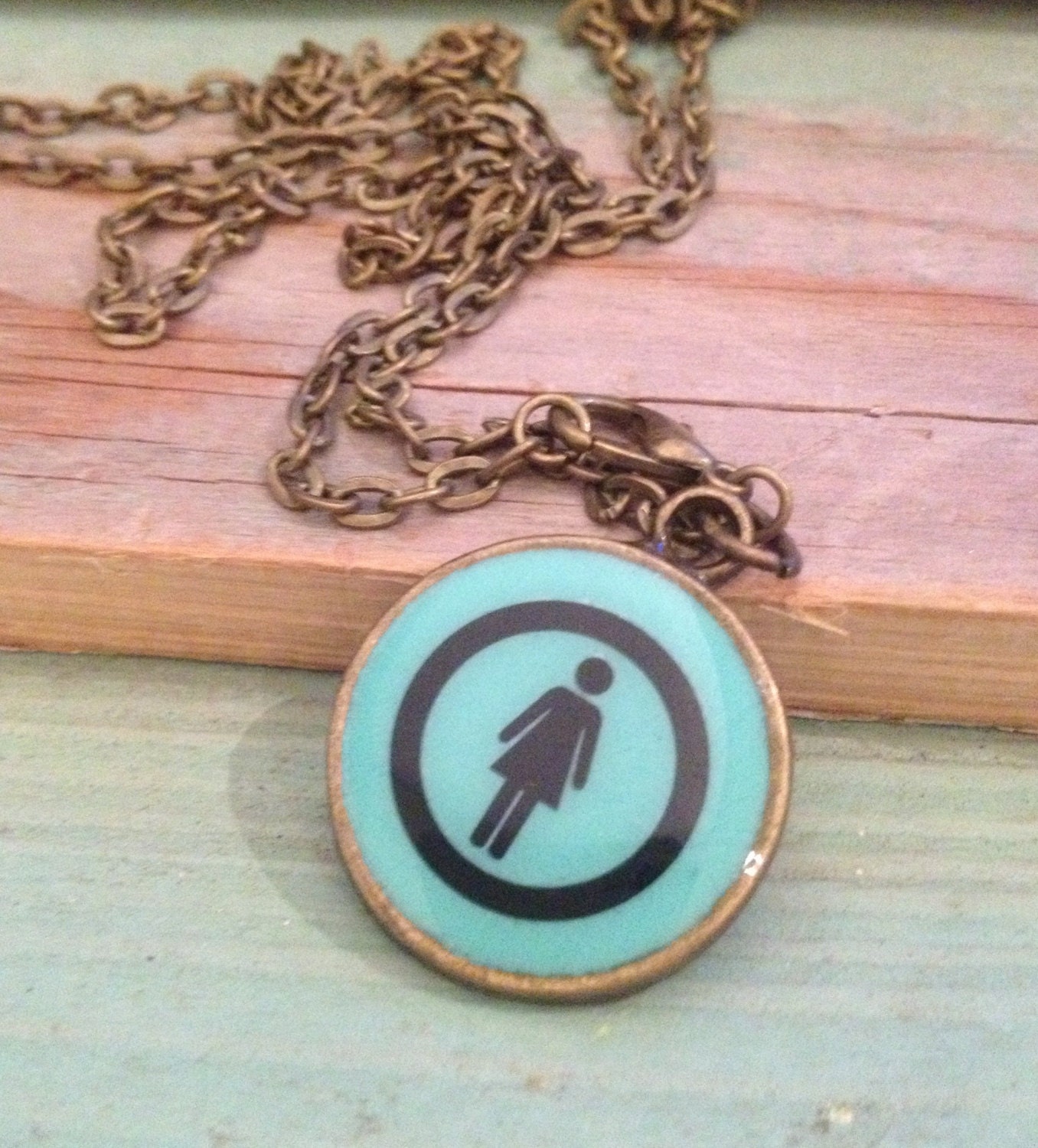 Aqua lady pendant necklace on bronze setting. 22mm. Quirky toilet sign.