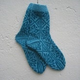 Handknitted norwegian socks for women in light turquoise and dark turquoise pattern.