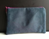 dark blue pouch made of faux leather with stitched geometric lines in dark violet