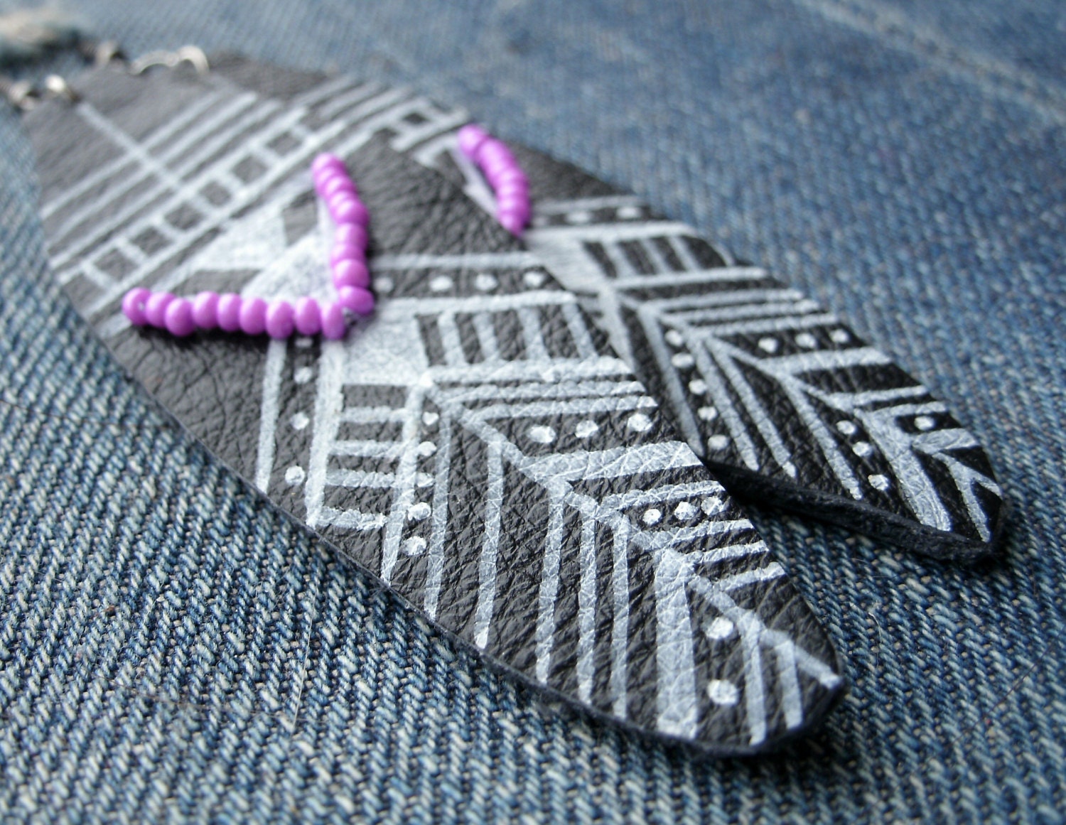 black leather feather earrings with tribal geometric design and bead detail handmade from salvaged material