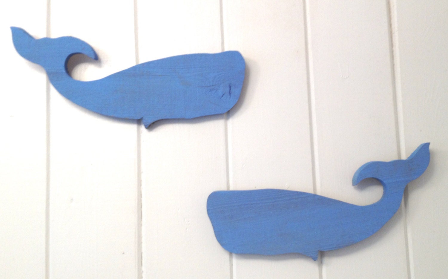 Rustic wooden sperm whale wall hangings.