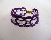 Handcrafted purple bracelet  with beads and ribbon.