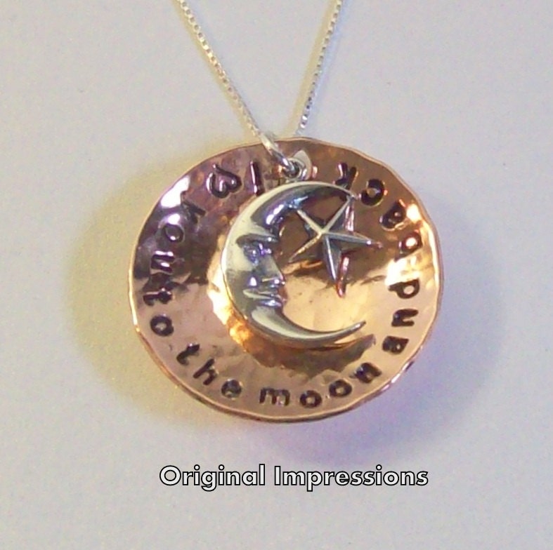 I love you to the moon and back pendant necklace of hammered and cupped copper with a sterling silver moon charm on a sterling silver chain.