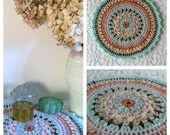 Mandala crochet decorative table mat doiley. Turquoise, soft orange, pale pink and pale ornage with a natural / beige and brown highlight