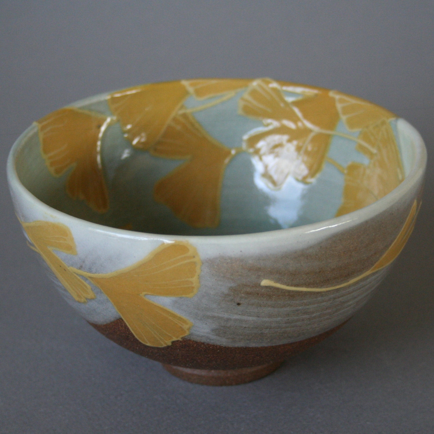 handmade stoneware bowl or chawan or with vibrant yellow ginkgo leaves in Japanese/Craftsman style