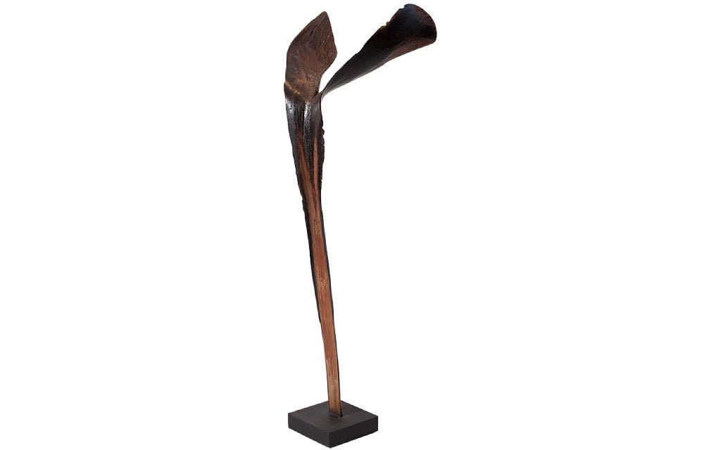 Unique wonderfully organic handmade sculpture featuring a lacquered palm leaf mounted on a black metal stand