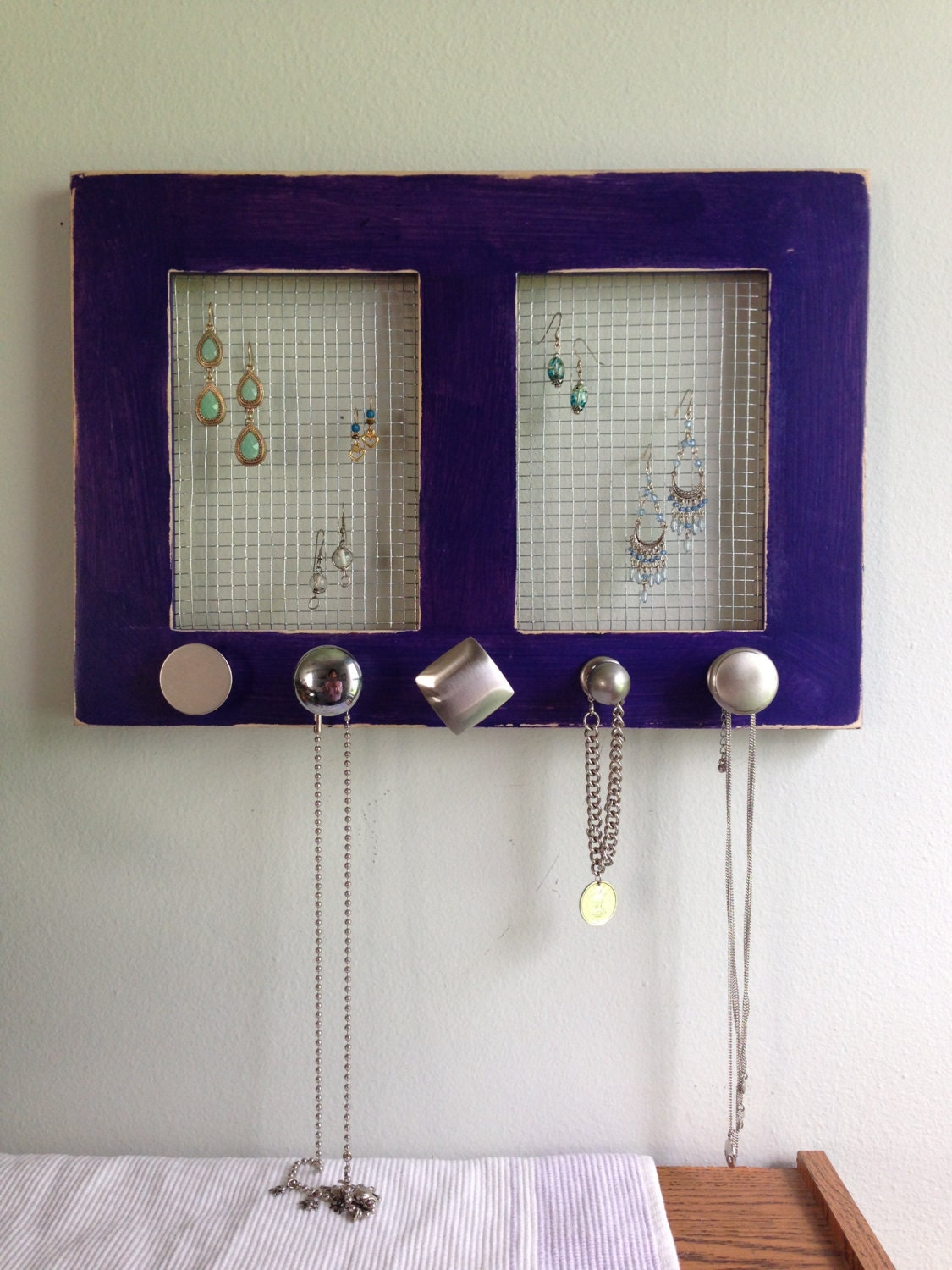 upcycled purple wood frame jewelry holder with five funky silver knobs