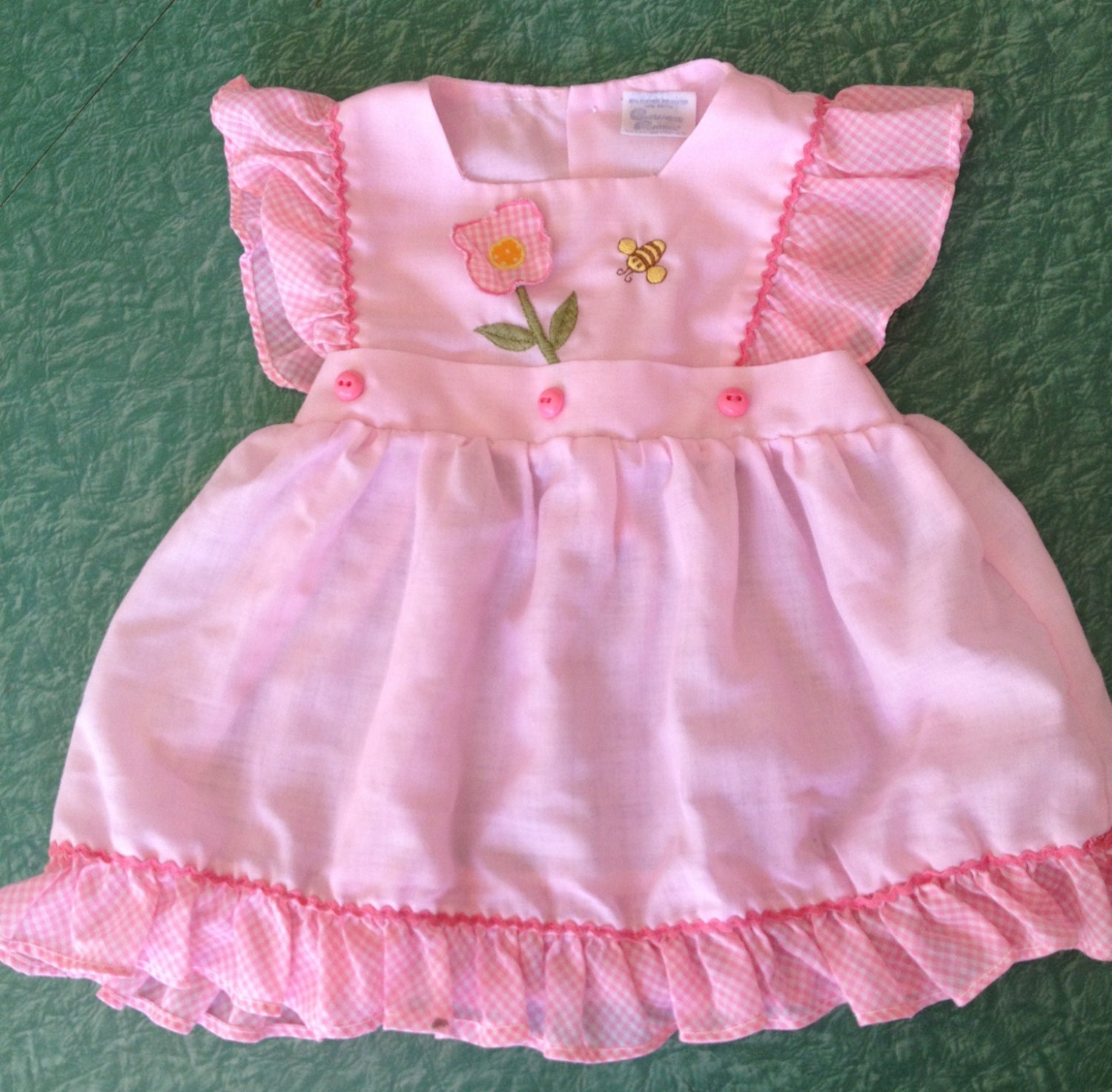 Baby pink pinafore in size 12-18 months, ruffled sleeves and flower/bumblebee detail