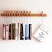 Custom made wooden book rack / bookshelf in Oak. The pins are also bookmarks.
