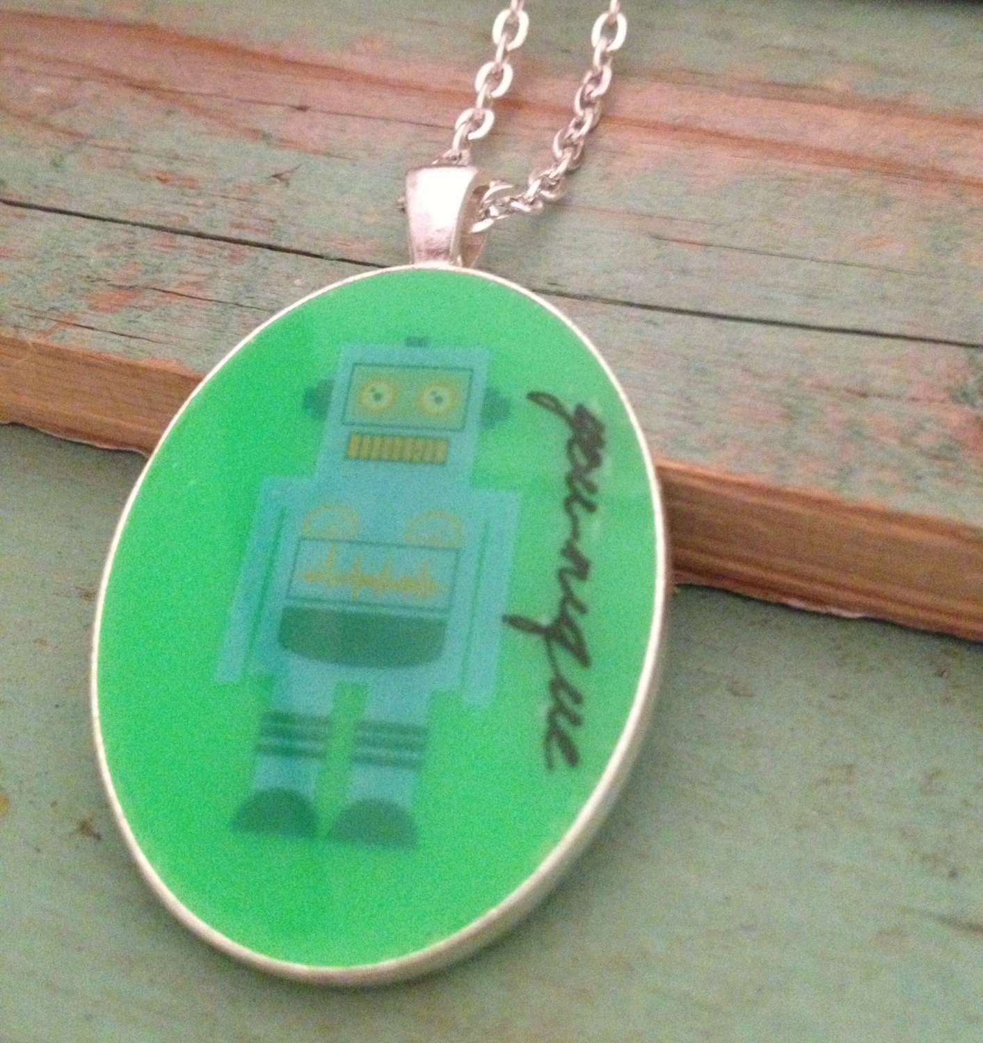 Bright green resin pendant necklace with cute robot and word 'you-nique'. Large oval 30 x 40mm