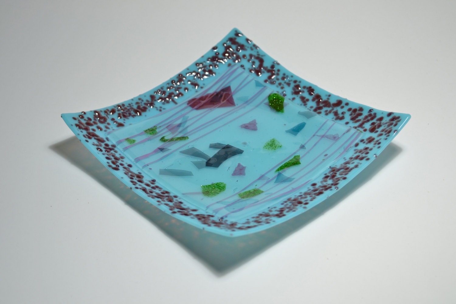 Light Blue Glass Plate with Purple Pebbles and Floating Bits