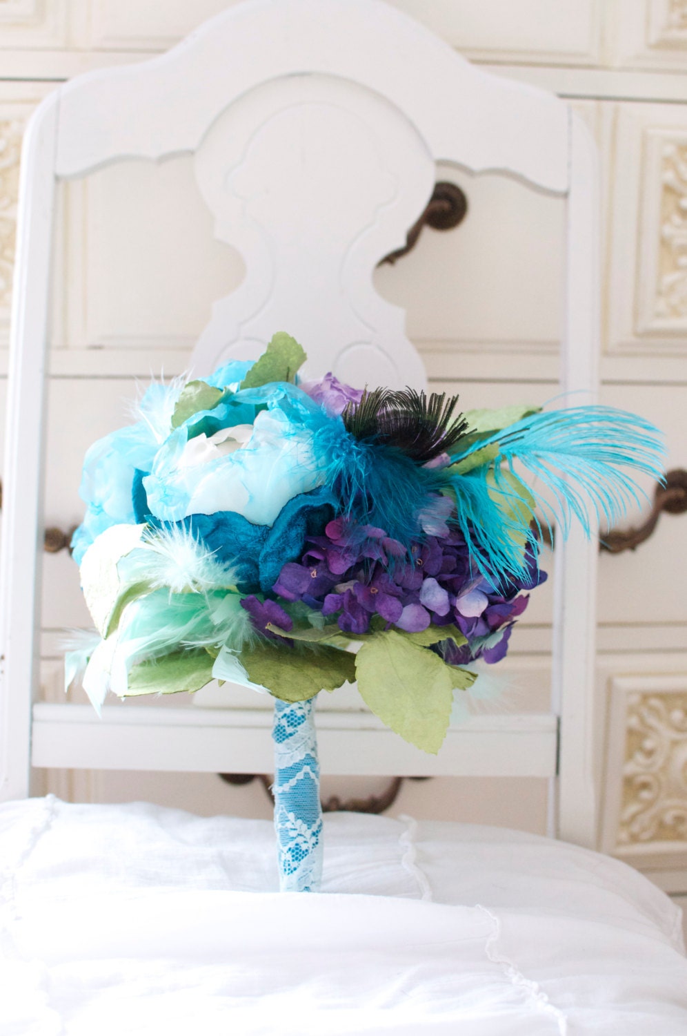 Purple and Aqua fabric and paper flowers paired with Greens and feathers for a stunning wedding bouquet