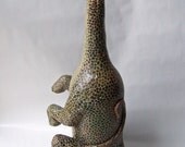 Dinosaur sculpture made of paper mache and wine bottle