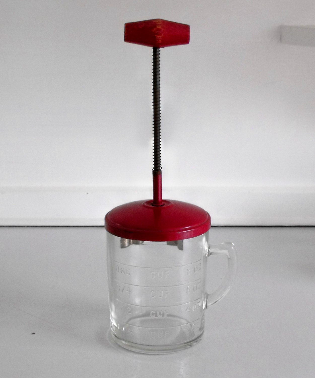 Vintage Hazel Atlas food chopper and measuring glass in red from the 1940s