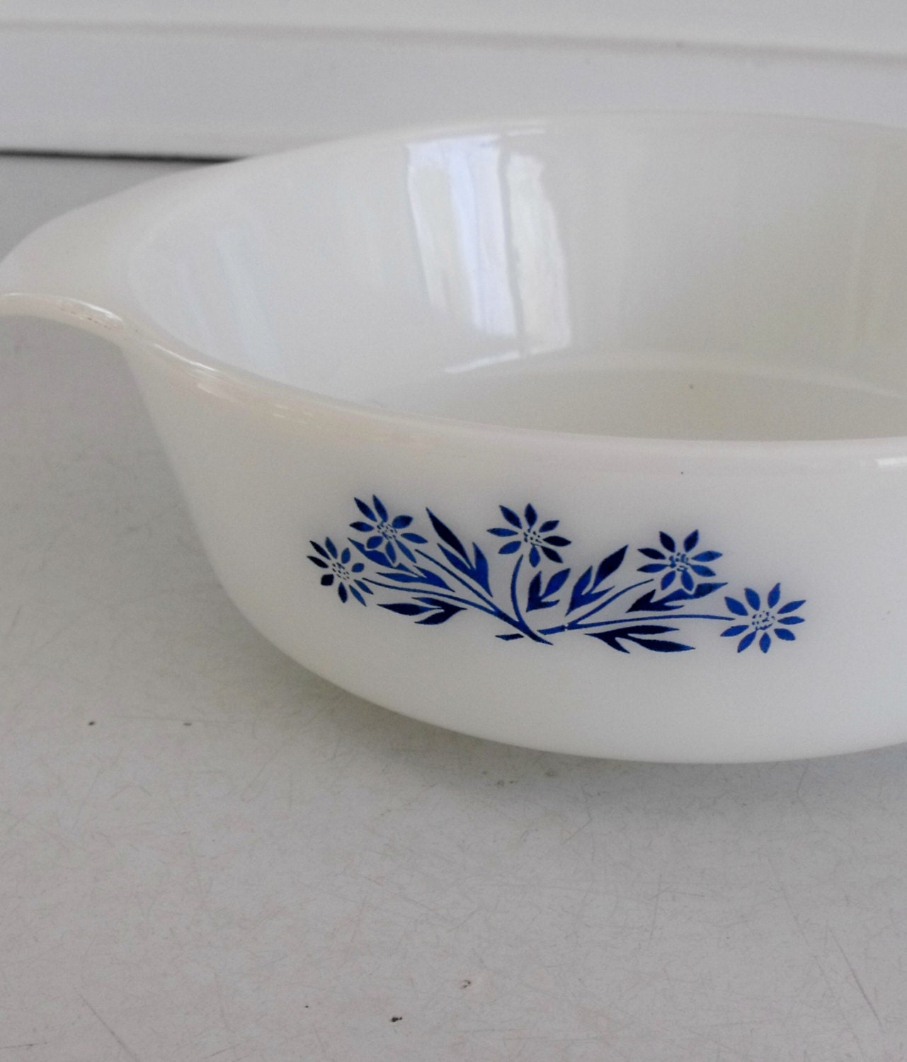 Vintage Fire King casserole with handles, glossy white with blue floral motif