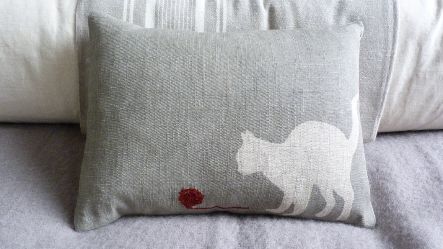 hand printed muted grey cat cushion with little wool ball