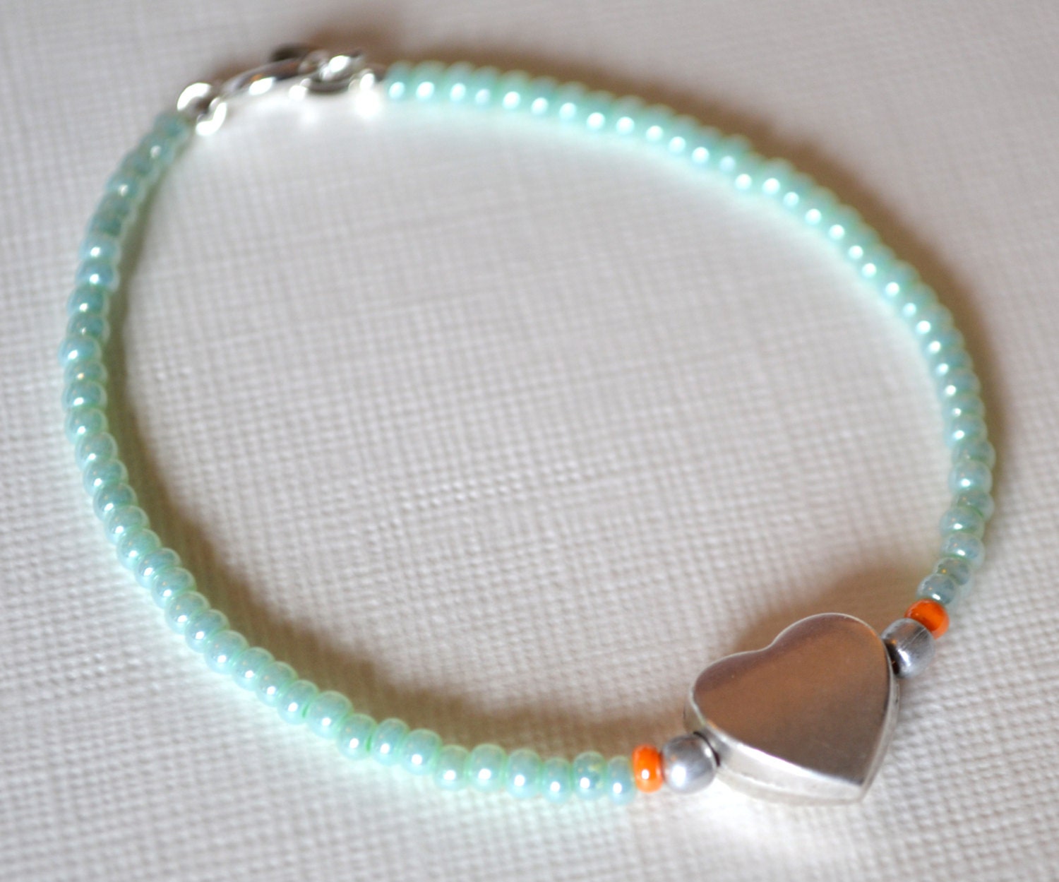 Elegant, mint green beaded friendship bracelet with silver love heart charm.