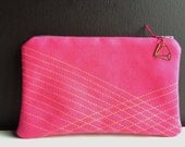 neon pink pouch made of faux leather with neon pink geometric stitches