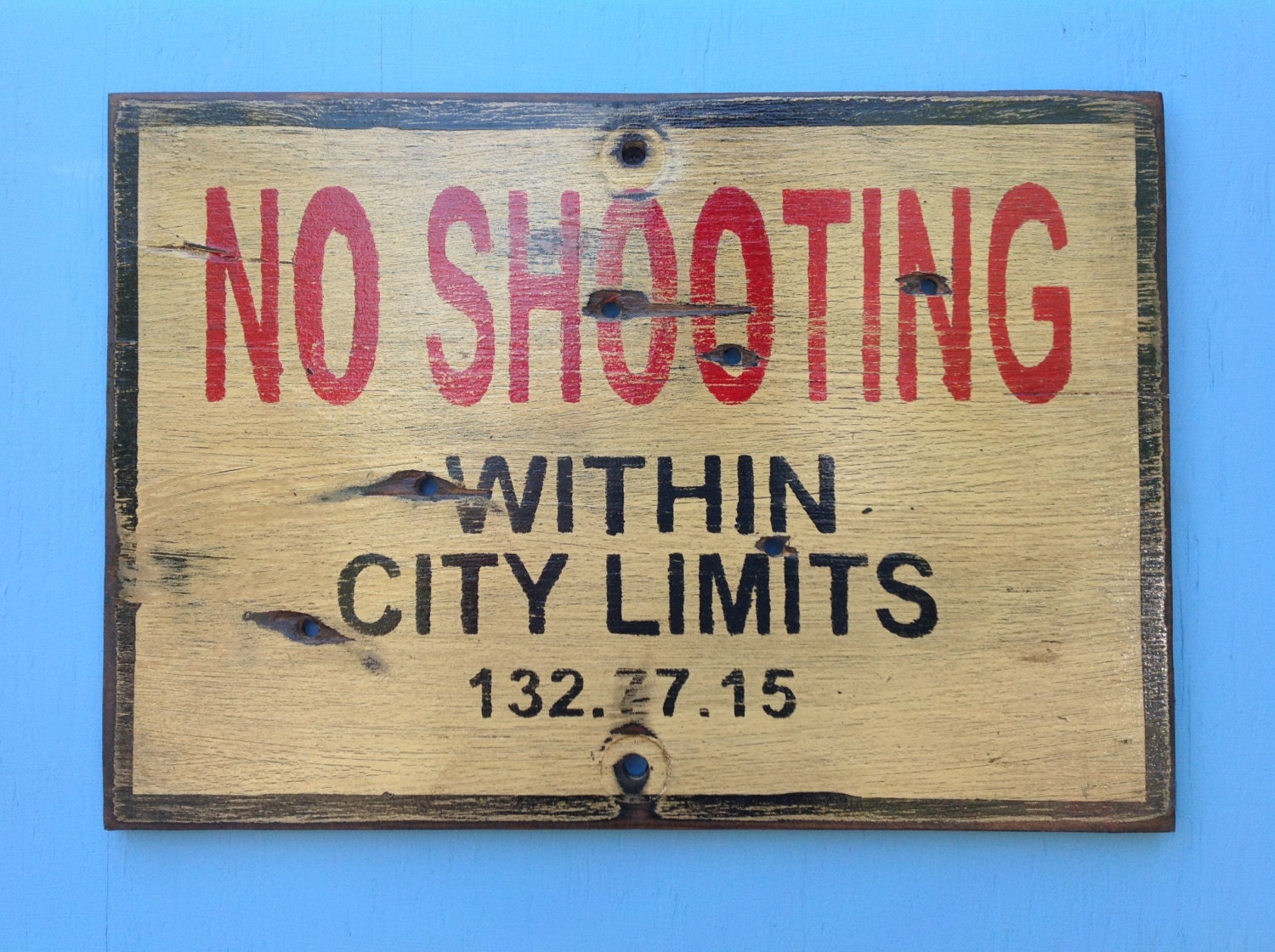 Wooden sign No shooting within city limits sign made from reclaimed plywood