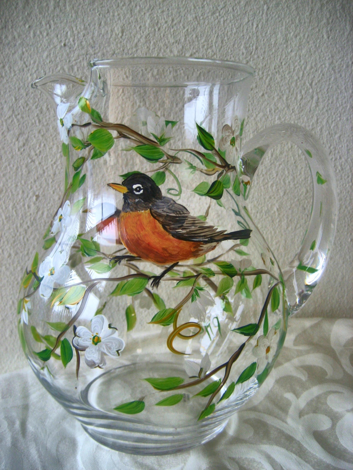 Large hand painted glass pitcher with robins and dogwood blossoms.