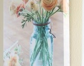 Ranuculus in an antique blue ball jar wrapped canvas art print