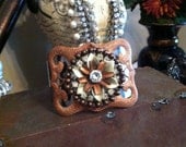 Metal cuff bracelet with metal flower and rhinestone accent