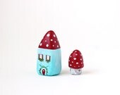 Little light blue clay house with red roof, flowers and polka dots and a tiny toadstool mushroom