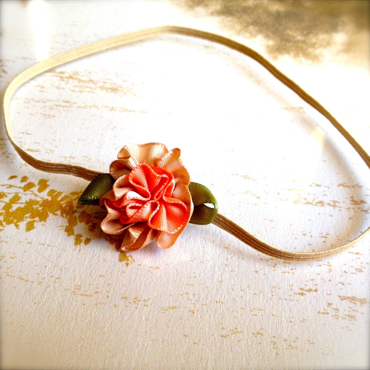Baby mini peach tan flower headband on skinny elastic. Photo prop. Flower girl, baby girl, newborn. Available in ten colors.