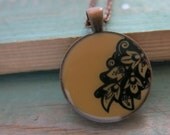 Camel tan brown pendant necklace with black floral motif. Copper finish. 1 inch