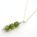 Three peas in a pod, green mother of pearl peapod pendant necklace on sterling silver chain.