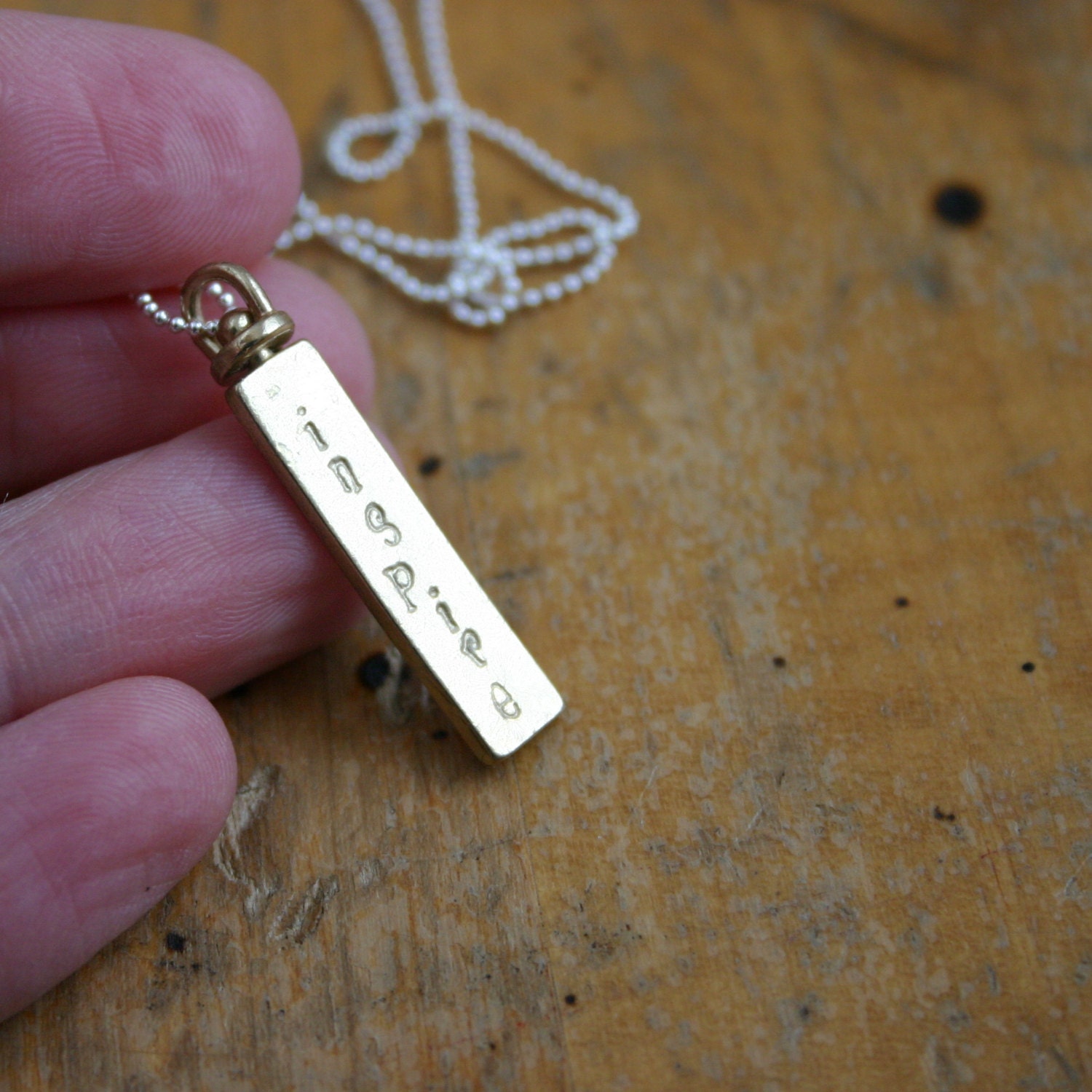 Brass inspire necklace on two sided swivel pendant and long chain