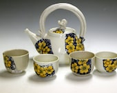 Ceramic and pottery tea set with four matching tea bowls.