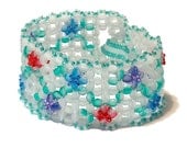 Flowers in Glass Bracelet beadwoven with purple, red and blue flowers with emerald green leaves and sparkle highlites