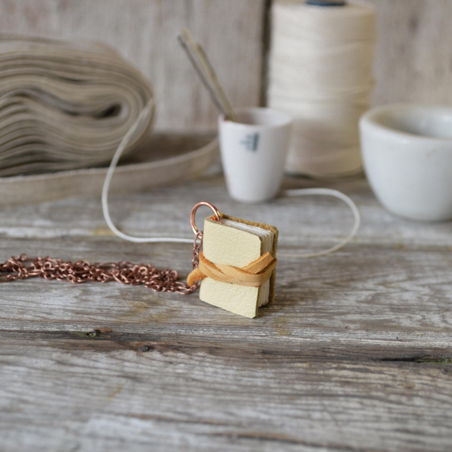 Book Necklace: Medium, pale yellow tied with deerskin, reclaimed leather.