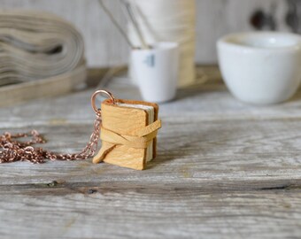 Book Necklace: Medium, mid-century deerskin, tied.