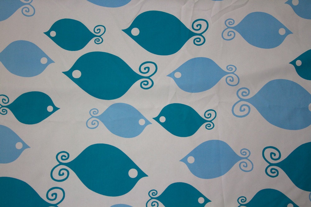 Fitted crib sheet with teal and blue fish print on a beige base fabric. Brushed soft textile.