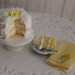 Miniature Coconut Cake With A Yellow Rose, A Slice Of Cake, And A Yellow Linen Towel With A Rose