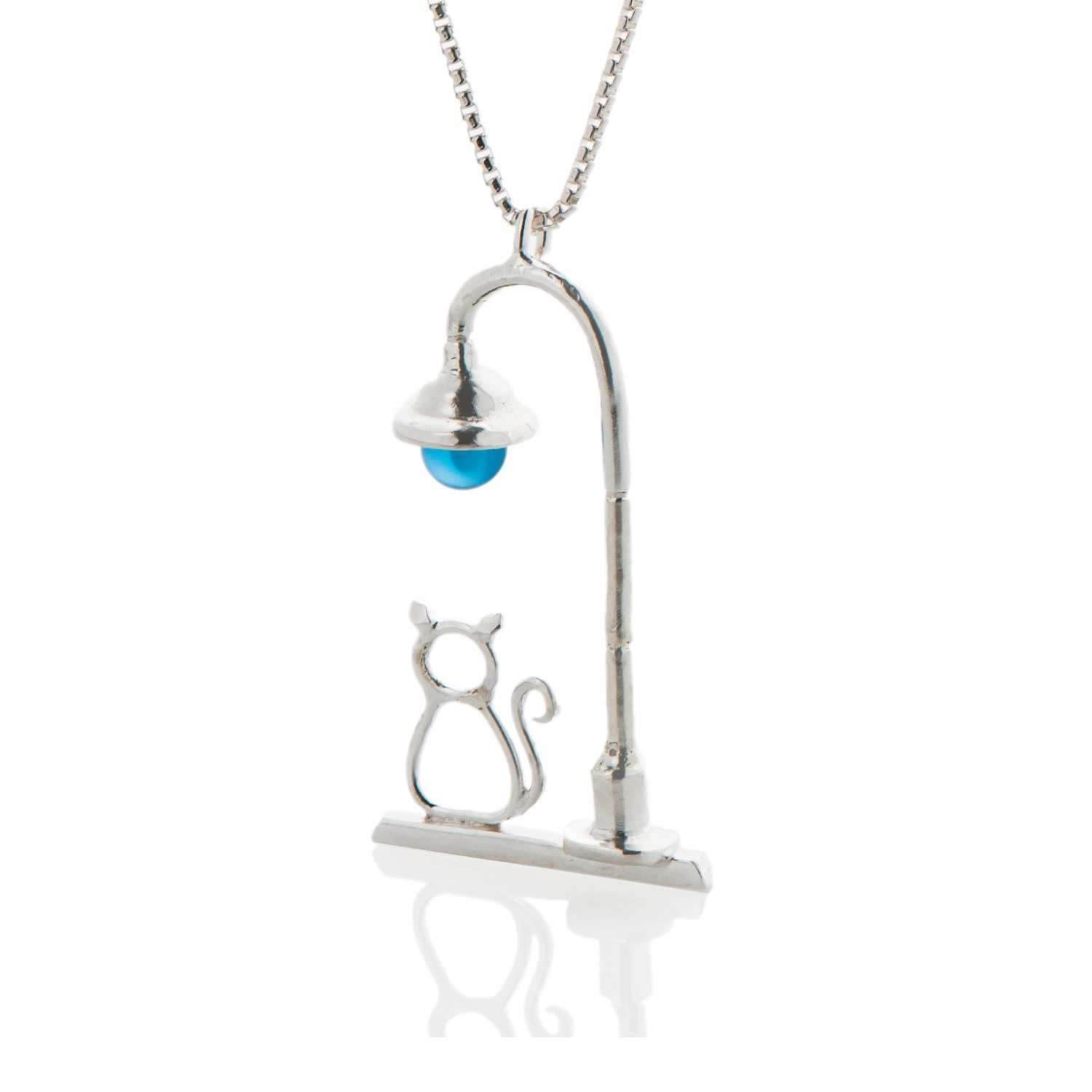 A silver necklace with a Cat sitting under a beautiful lamp-post.