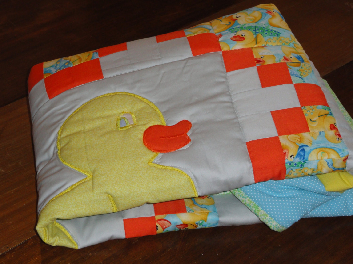 Appliqued Baby Duckie Baby Quilt,  Patchwork background in light blue and yellow highlights the Cute little Duck