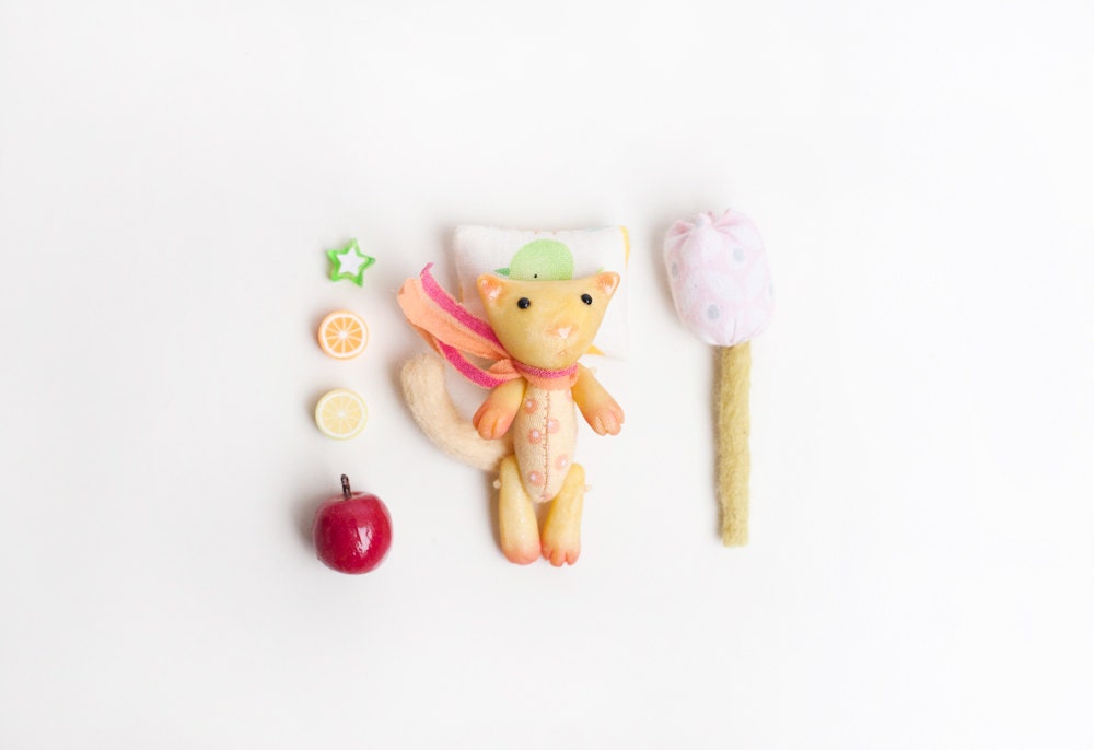 Tiny sunny cat in a matchbox. Pocket miniature toy animal, yellow. Small sleeping cat in bed.