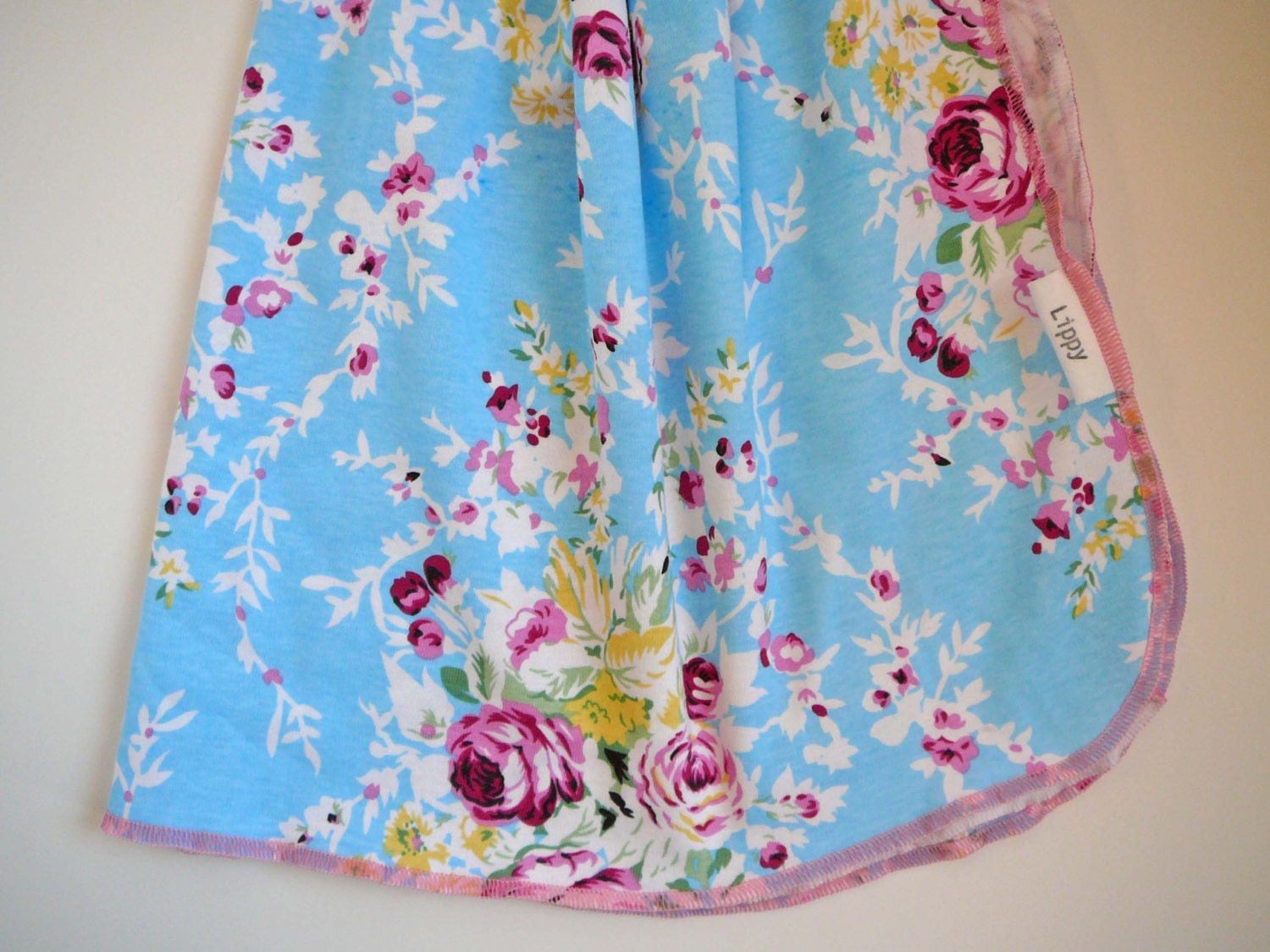 Floral baby blanket. Size 31 by 40 inches. Bright blue floral print with pink edging. Darling for baby girl.