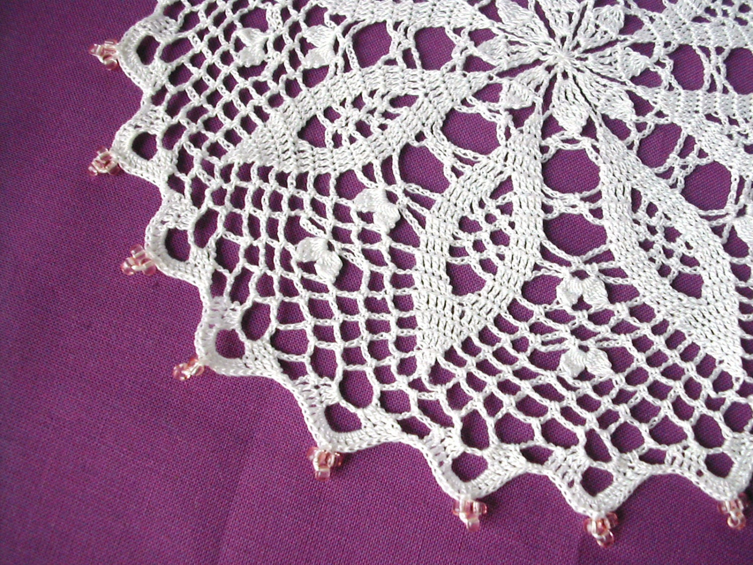 Pure white crochet lace doily with pink beads