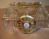 Textured Goldtone Locket with Filigree and Mother of Pearl on 24" Twisted Chain  On Sale 5.00