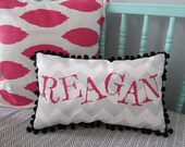 Pillow in light gray chevron with bright pink personalized name.