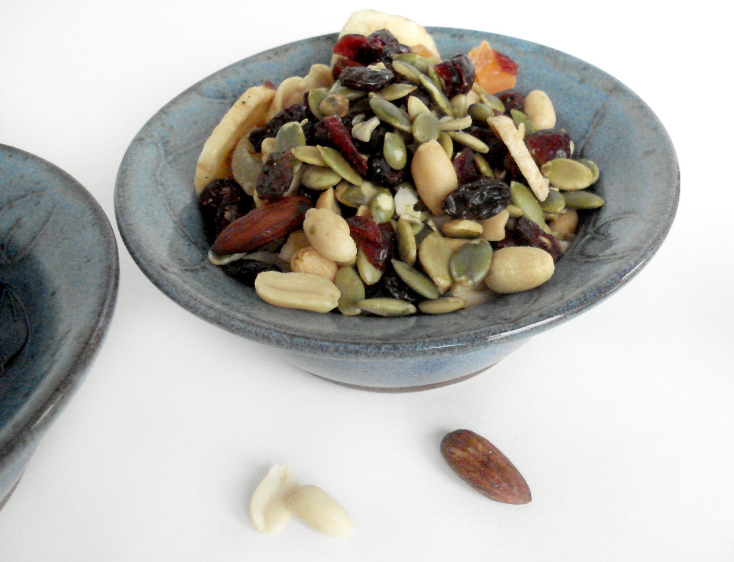 Small handmade blue pottery bowl with carved leaf design