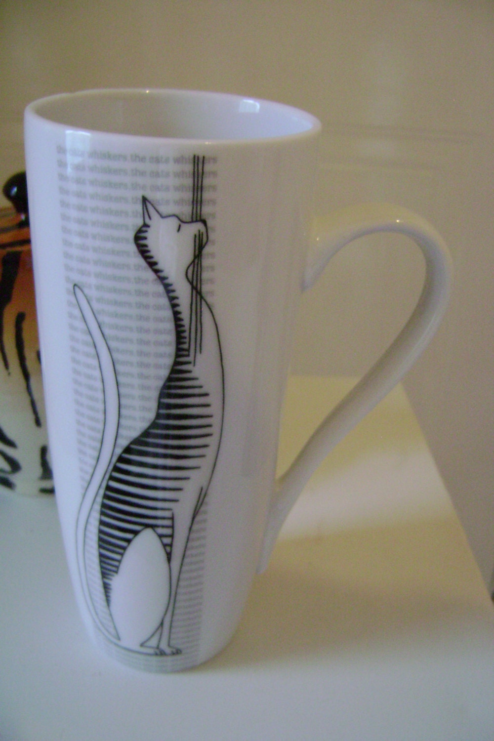1970s style tall mug for someone you think is "the cat's whiskers" (super) - white with black striped cat and background writing in grey