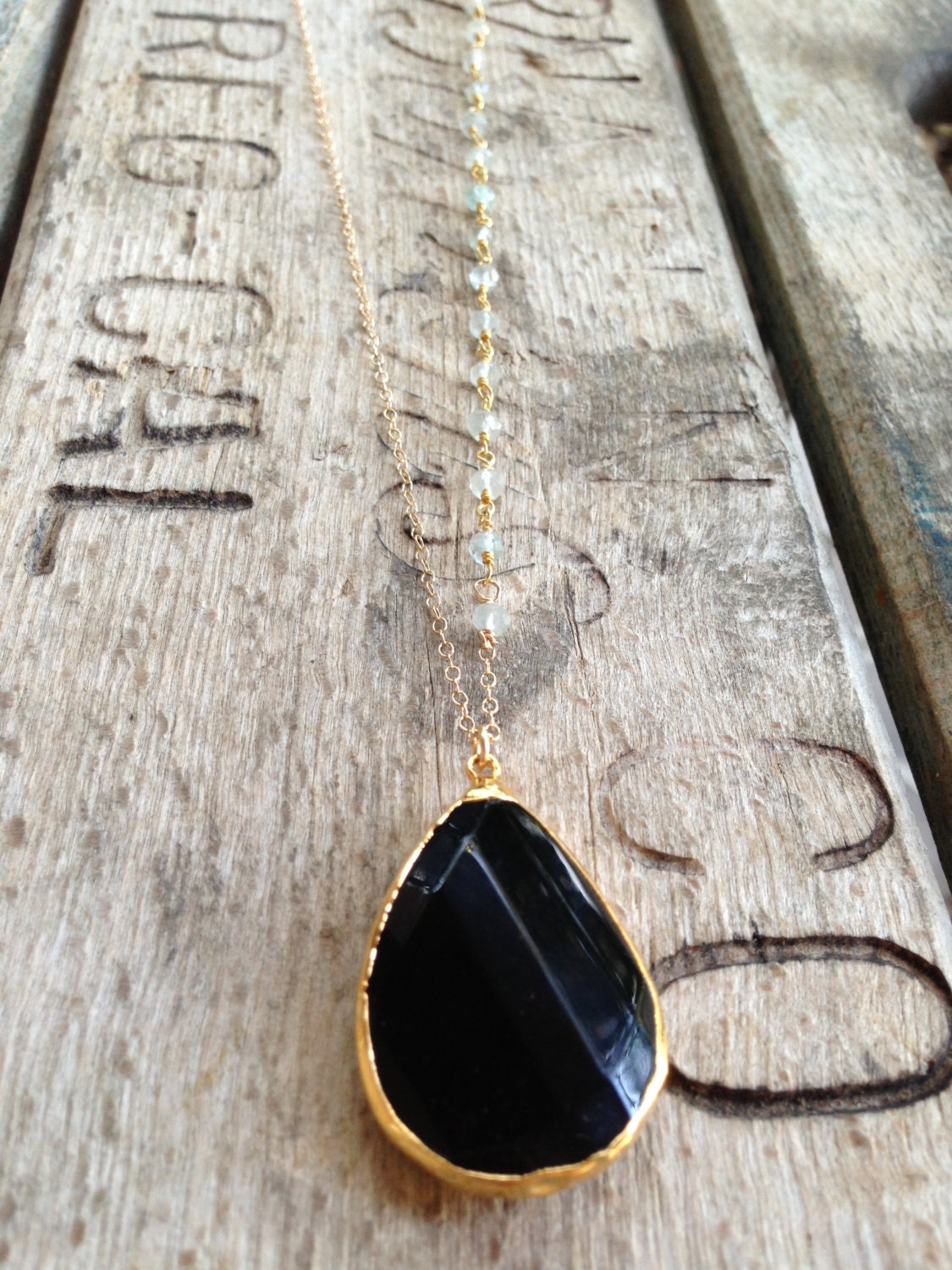 Gold edged black spinel stone necklace with wire wrapped aquamarine stone