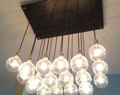 Custom Industrial Chandelier with Modern Glass Pendants in Polished Nickel Sockets hung from Rayon Cord attached to Premium Base