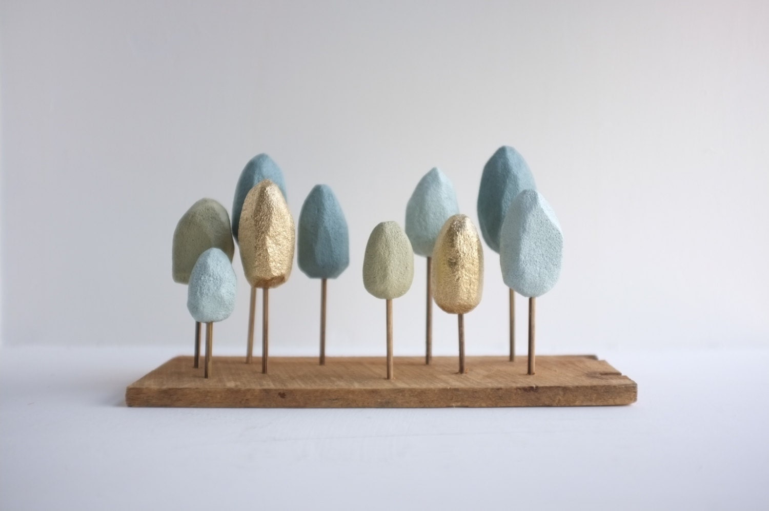 Pastel and gold miniature forest of hands carved trees