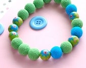 Lovely grass green and sky blue round bead crochet necklace with painted wood beads with pink and cyan flower motif and string ties